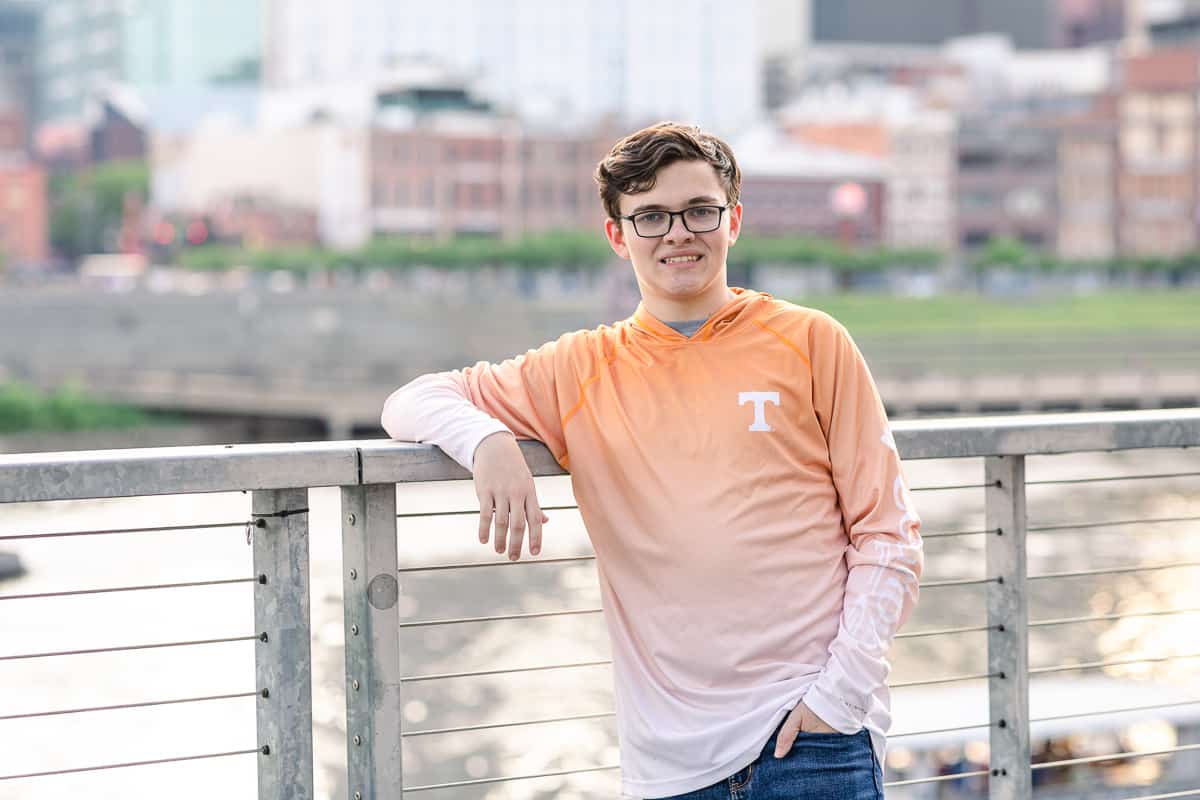 Senior boy in UT shirt next to river